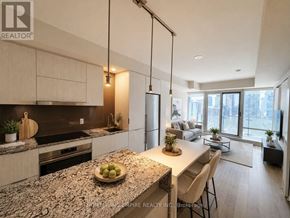 Toronto (Clairlea-Birchmount) condo for rent - A modern kitchen with granite countertops and a dining area with a view of the city.