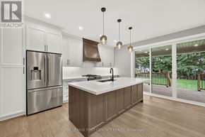 Innisfil (Alcona) apartment for rent - A modern kitchen with a refrigerator, sink, and cabinets.