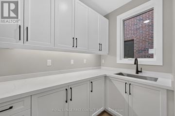 Innisfil (Alcona) apartment for rent - A kitchen with white cabinets and a brick wall in the background.