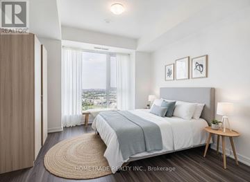 Vaughan (Concord) condo for rent - A bedroom with a large bed and a view of the city.