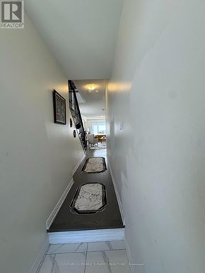 Barrie apartment for rent - A hallway with a white wall and a black and white tile floor.