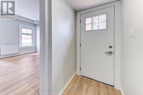 Barrie (North Shore) multi-family for rent - A white door with a window above it in a room with wooden floors.