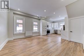 Barrie (North Shore) multi-family for rent - A large, empty room with wood flooring and white walls.