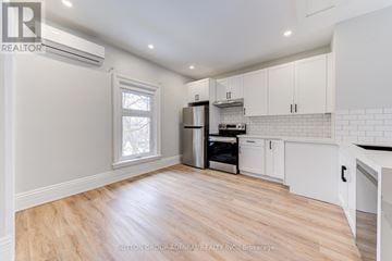 Barrie (North Shore) multi-family for rent - A kitchen with white cabinets and a wooden floor.