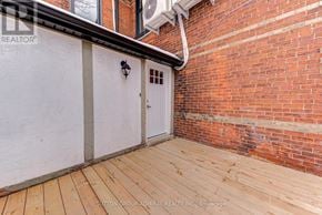 Barrie (North Shore) multi-family for rent - A wooden deck with a white door and a brick wall.