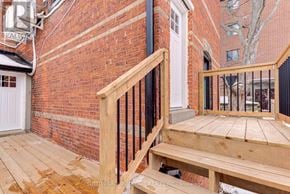 Barrie (North Shore) multi-family for rent - A wooden deck with a bench and a black railing.