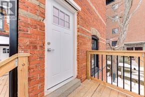 Barrie (North Shore) multi-family for rent - A white door is on the left side of a brick wall.