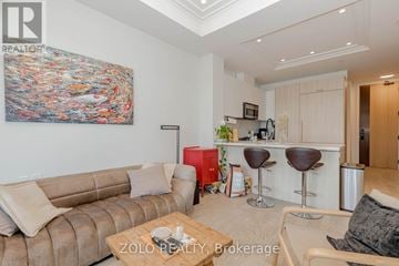 Oakville (Co Central) condo for rent - A living room with a couch, a coffee table, and a painting on the wall.