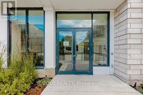 Oakville (Co Central) condo for rent - The entrance to a building with a glass door and a sign that reads "ZOLO REALTY, Brokerage".