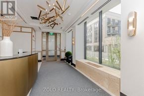 Oakville (Co Central) condo for rent - A reception area with a gold reception desk and a view of the outside.