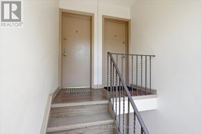 Toronto (Mimico) multi-family for rent - A staircase with a metal railing and wooden steps leading to a door.