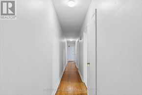 Toronto (Mimico) multi-family for rent - A long hallway with white walls and a wooden floor.