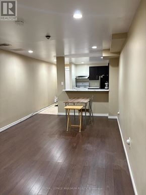 Toronto (Weston-Pellam Park) multi-family for rent - A room with a wooden floor and a table with chairs.