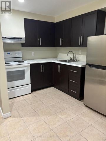 Toronto (Weston-Pellam Park) multi-family for rent - A kitchen with black cabinets and stainless steel appliances.