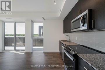 Oakville (Jm Joshua Meadows) condo for rent - A kitchen with a microwave on the wall and a stove top oven.