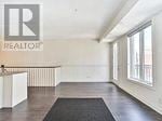 Toronto (Long Branch) townhouse for rent - A realtor sign is on the wall in an empty room.