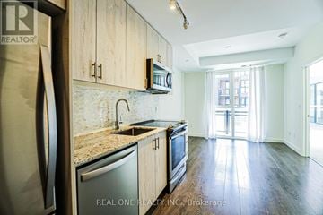 Oakville (Go Glenorchy) condo for rent - A kitchen with wooden cabinets and a granite countertop.