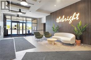 Kitchener condo for rent - A modern office lobby with a large glass door and a neon sign that says "thebright".