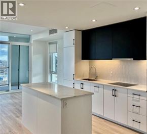 Kitchener condo for rent - A modern kitchen with white cabinets and a large island.