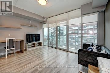 Waterloo condo for rent - A living room with a couch, television, and sliding glass doors.
