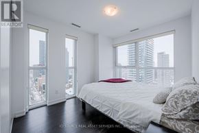 Toronto (Mount Pleasant West) condo for rent - A bedroom with a large bed and a view of the city.