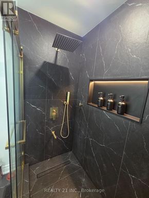 Toronto (Rouge) apartment for rent - A bathroom with a marble wall and a gold shower head.