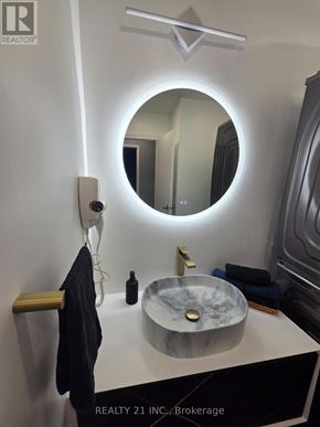 Toronto (Rouge) apartment for rent - A bathroom with a round mirror and a marble sink.