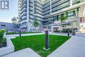 Richmond Hill (Langstaff) condo for rent - A modern building with a green lawn in front.
