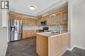 Stoney Creek townhouse for rent - A kitchen with wooden cabinets and a stainless steel refrigerator.