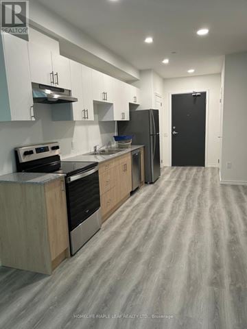 Guelph (Willow West/Sugarbush/West Acres) condo for rent - A kitchen with a stove top oven, refrigerator, and cabinets.