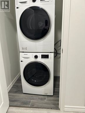 Guelph (Willow West/Sugarbush/West Acres) condo for rent - A white front loading washing machine with a black door is in a small laundry room.