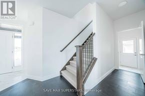 London South (South W) apartment for rent - A staircase with a wooden banister and a beige carpeted runner leads up to a white door.