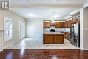 Hamilton (Mewburn) townhouse for rent - A kitchen with wooden cabinets and a refrigerator.
