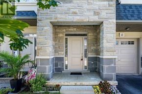 Hamilton (Mewburn) townhouse for rent - A stone building with a white door and a sign that says RE/MAX Realty Services Inc.