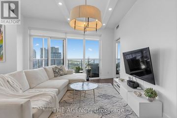 Toronto (Niagara) condo for rent - A living room with a white couch and a flat screen TV.