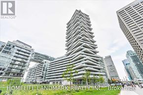 Toronto (Waterfront Communities) condo for rent - A tall building with a unique design stands out among other buildings in a cityscape.