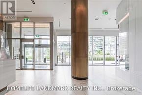 Toronto (Waterfront Communities) condo for rent - The lobby of a building with a glass door entrance and a wooden column.