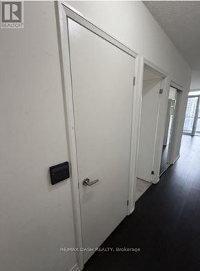 Toronto (Church-Yonge Corridor) condo for rent - A hallway with white doors and a black control panel on the wall.