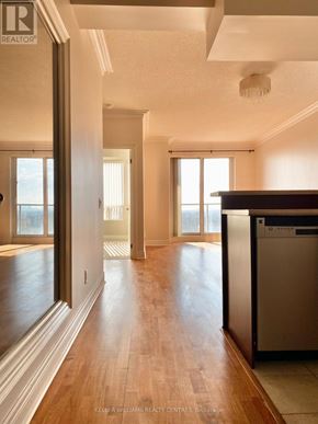 Toronto (Willowdale East) condo for rent - A real estate listing photo of a kitchen with wood floors and a stainless steel dishwasher.