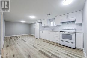 Toronto (Pleasant View) apartment for rent - A white kitchen with wooden floors and white cabinets.