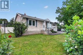 Ottawa apartment for rent - A house with a well-kept lawn and a red flower in the foreground.