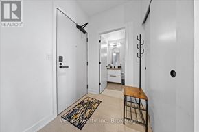 Ottawa condo for rent - A hallway with a rug on the floor and a mirror on the wall.