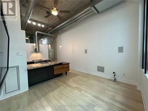 Toronto (Niagara) condo for rent - A spacious room with a kitchen island and wood flooring.