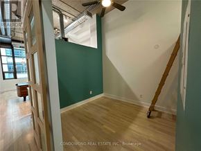 Toronto (Niagara) condo for rent - A room with a green wall and a wooden floor.