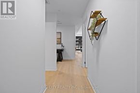 Toronto (Thorncliffe Park) condo for rent - A hallway with a wooden floor and a wall hanging.