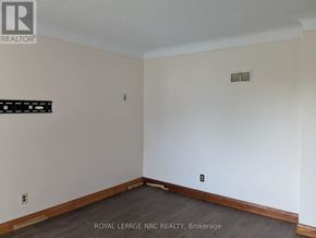 Port Colborne (Main Street) apartment for rent - A room with a white wall and a black sign on it.
