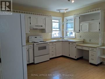 Port Colborne (Main Street) apartment for rent - A kitchen with white appliances and cabinets.