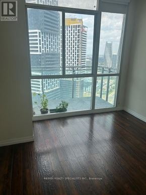 Mississauga (City Centre) condo for rent - A room with a view of the city through a large window.