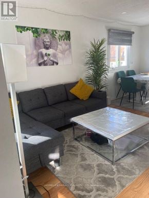 Brampton (Sandringham-Wellington) apartment for rent - A living room with a grey couch and a glass coffee table.