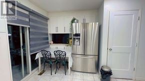 Brampton (Sandringham-Wellington) apartment for rent - A kitchen with a stainless steel refrigerator, a dining table with chairs, and a fire extinguisher.